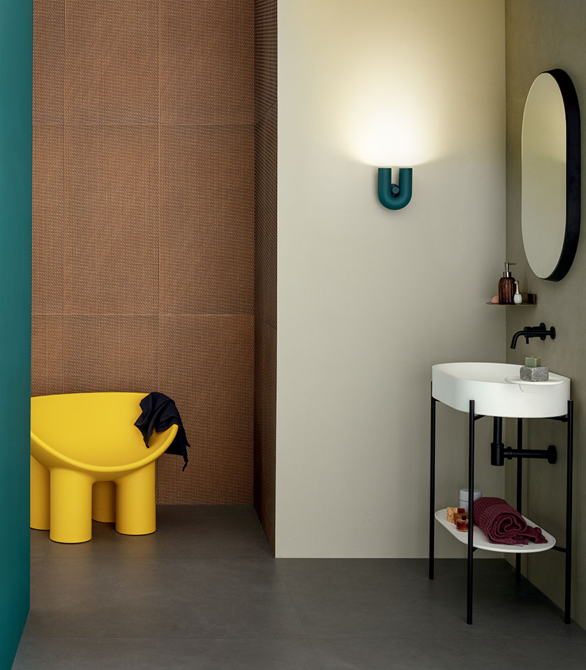 Salle de bains moderne avec surfaces texturées, tons neutres et touches de couleur vives.