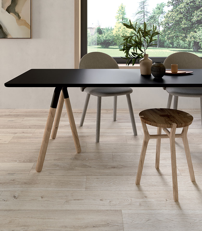 Espace repas contemporain avec table noire et assises en bois, sur un sol de la collection Bio Attitude effet bois dans la teinte Cotton.