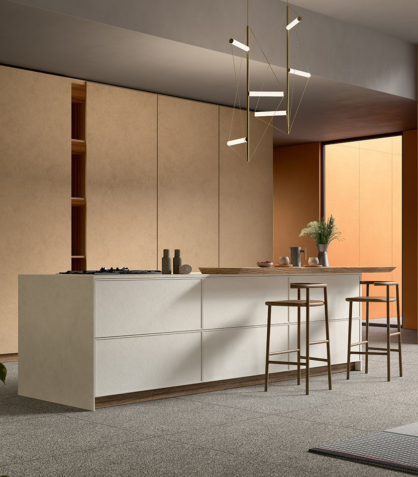 Cuisine contemporaine avec îlot central et tabourets, revêtements de la collection Pigmenti dans les teintes Harvest, Mist et Sunset, associés au sol Piece Dark.