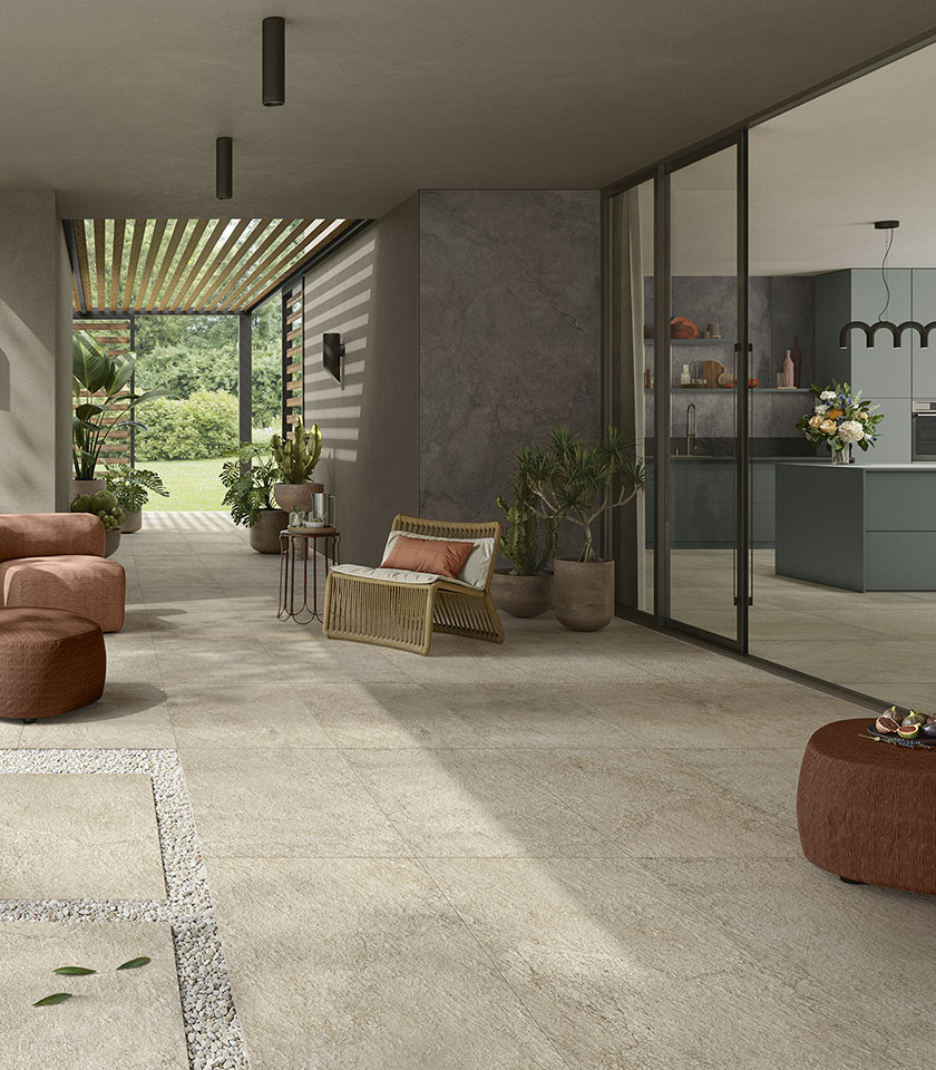 Espace de vie intérieur-extérieur contemporain avec sol de la collection Pulse effet pierre dans la teinte Sand Rough et revêtements muraux dans la teinte Shadow.