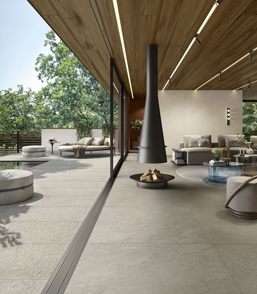 Espace de vie intérieur-extérieur contemporain avec sol de la collection Pulse effet pierre dans la teinte Clay, finition Clay Rough pour l’extérieur et revêtements muraux dans la teinte Shell.
