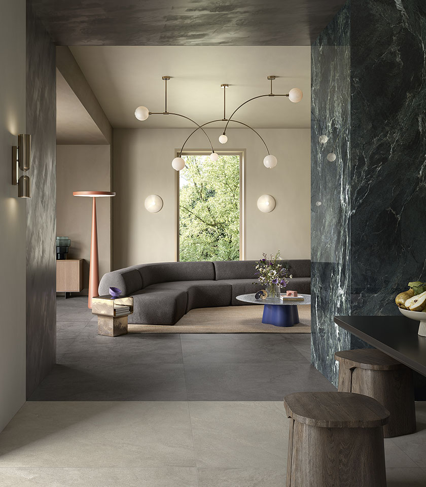 Salon contemporain avec sol de la collection Pulse effet pierre dans les teintes Clay et Shadow et revêtement mural de la collection Noblesse effet marbre Verde Alpi.