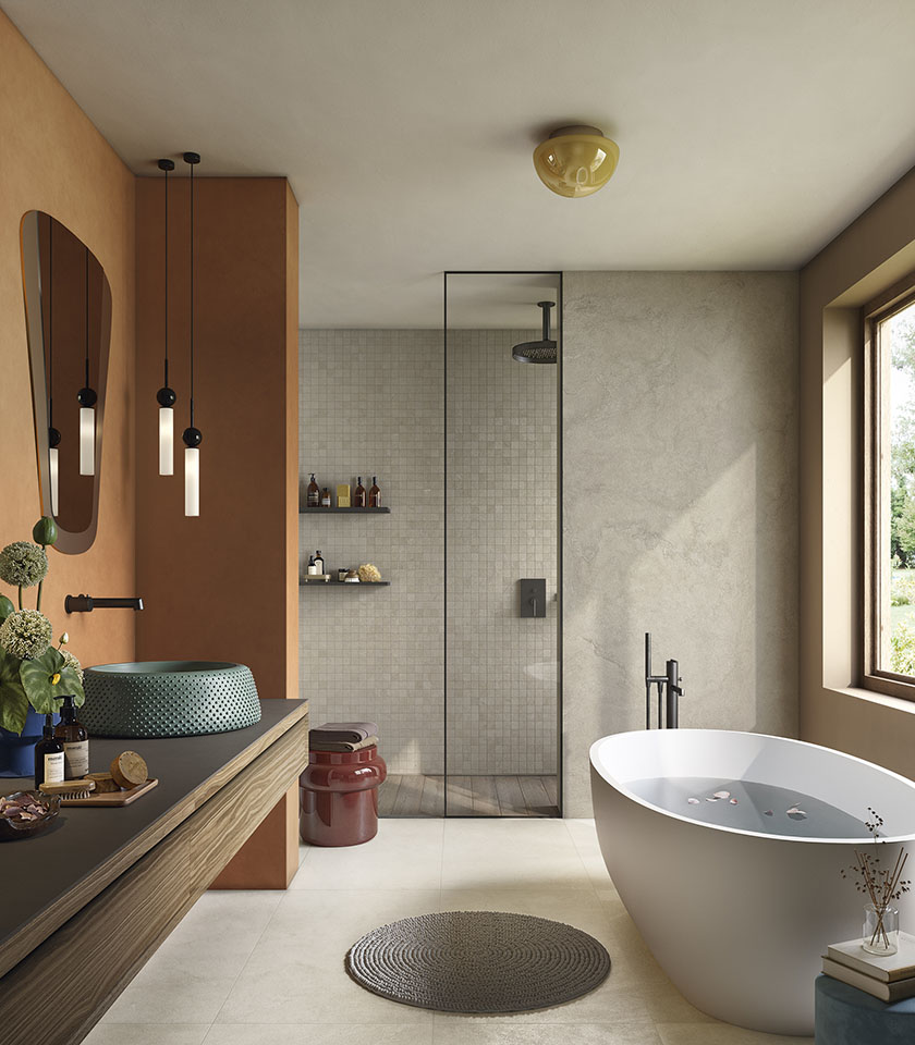 Pulse Shell et Clay composent une salle de bains lumineuse et texturée, où surfaces céramiques effet pierre, mosaïques et tonalités chaudes créent une atmosphère naturelle et contemporaine.
