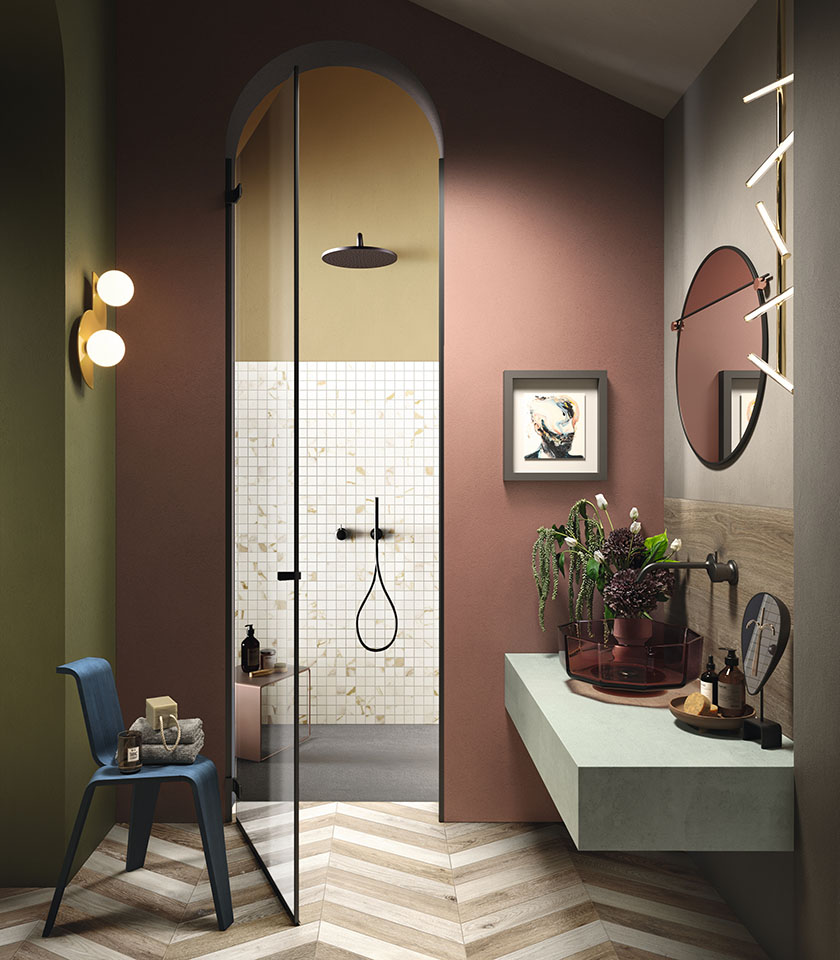 Salle de bains sophistiquée avec sol effet bois en chevrons, mosaïque effet marbre et teintes enveloppantes pour une ambiance originale et contemporaine.